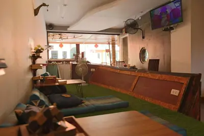 a living room with a couch and a table at Baan Kamala Backpacker in Kamala Beach