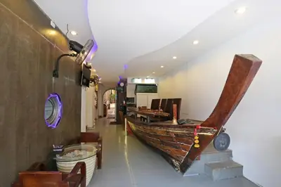 a room with a wooden boat on the wall at Baan Kamala Backpacker in Kamala Beach