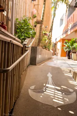 a street with a white arrow on the sidewalk at Baan Kamala Backpacker in Kamala Beach