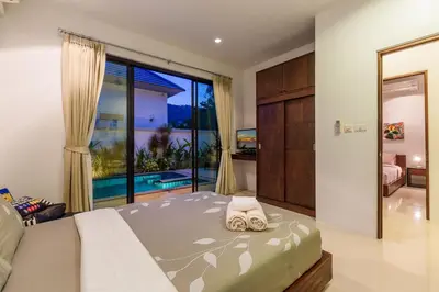 a bedroom with a bed and a large window at Perfect 3br Pool Villa by Intira Villas in Rawai Beach