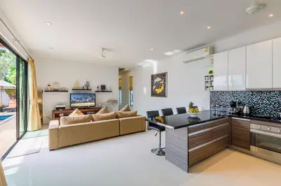 a kitchen and living room with a couch and a table at Perfect 3br Pool Villa by Intira Villas in Rawai Beach