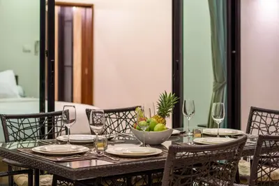 a dining table with a bowl of fruit and wine glasses at Perfect 3br Pool Villa by Intira Villas in Rawai Beach