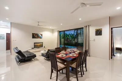 a dining room and living room with a table and chairs at Modern 3br Boutique Pool Villa by Intira Villas in Rawai Beach