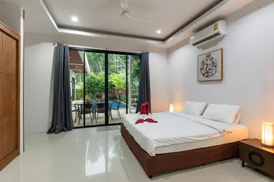 a bedroom with a bed and a balcony at Modern 3br Boutique Pool Villa by Intira Villas in Rawai Beach