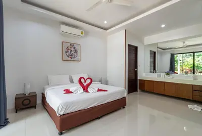 a bedroom with a bed with a bow on it at Modern 3br Boutique Pool Villa by Intira Villas in Rawai Beach