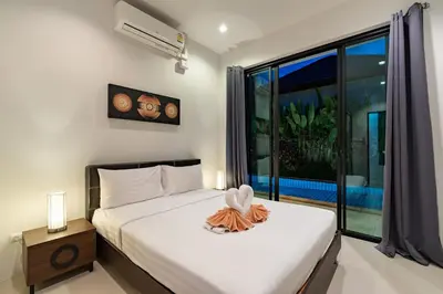 a bedroom with a bed and a large window at Modern 3br Boutique Pool Villa by Intira Villas in Rawai Beach
