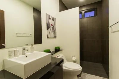 a bathroom with a white sink and a toilet at West facing 3br Boutique Pool Villa by Intira Villas in Rawai Beach