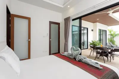 a bedroom with a large bed and a dining room at Big Buddha View 3br Pool Villa by Intira Villas in Rawai Beach