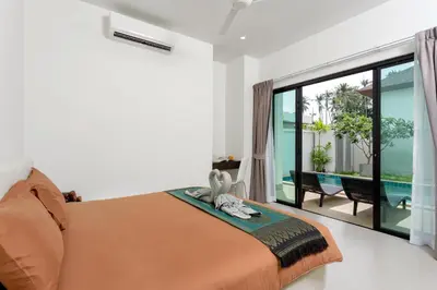 a bedroom with a bed and a large glass window at Big Buddha View 3br Pool Villa by Intira Villas in Rawai Beach