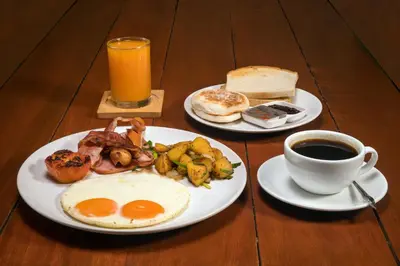 a table with two plates of breakfast food and a cup of coffee at Big Buddha View 3br Pool Villa by Intira Villas in Rawai Beach