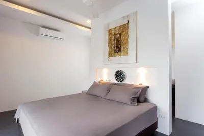 a bedroom with a large bed with white walls at Large 3br Boutique Villa with big Pool by Intira Villas in Rawai Beach