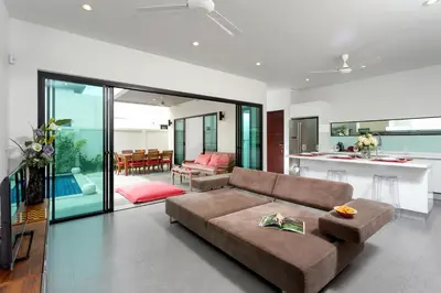 a living room with a couch and a kitchen at Large 3br Boutique Villa with big Pool by Intira Villas in Rawai Beach