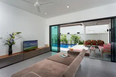 a living room with a couch and a tv at Large 3br Boutique Villa with big Pool by Intira Villas in Rawai Beach