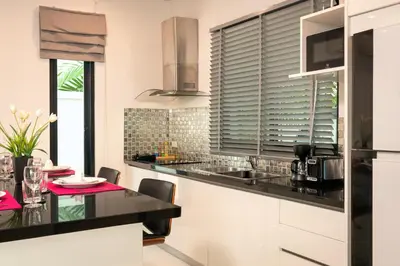 a kitchen with a black counter top and a table at Thai-Themed 3br Boutique Villa by Intira Villas in Rawai Beach