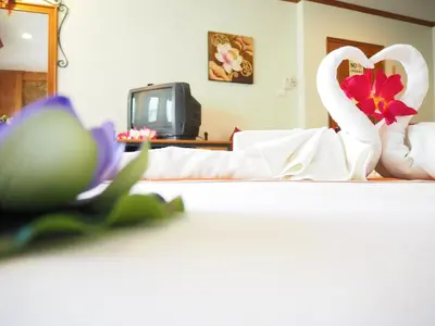 a bedroom with a bed with towels and a flower at Your Place Inn in Karon Beach