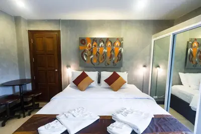 a bedroom with a bed with white shoes on it at Baan Kamala Fantasea Hotel in Kamala Beach