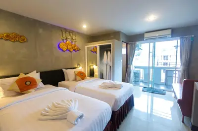 a hotel room with two beds and a balcony at Baan Kamala Fantasea Hotel in Kamala Beach