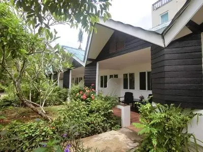 a house with a yard with flowers and plants at The Krabi Forest Homestay in Ao Nang Beach