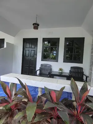 a porch with two chairs and a table with plants at The Krabi Forest Homestay in Ao Nang Beach