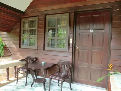 a porch with a table and chairs next to a door at The Krabi Forest Homestay in Ao Nang Beach