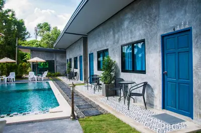 a house with a swimming pool and a blue door at Ongsa House in Bang Tao Beach