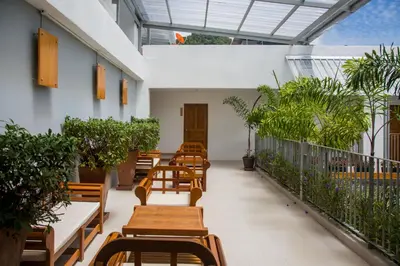 a row of tables and chairs in a building with plants at Nonnee Hotel Kata Beach Phuket in Kata Beach