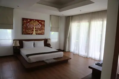 a bedroom with a bed and a large window at Laguna Villas Boutique Hotel in Ko Yao Noi