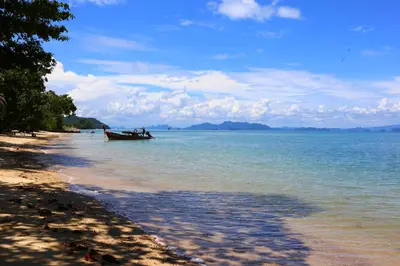 a boat in the water on a beach at Laguna Villas Boutique Hotel in Ko Yao Noi