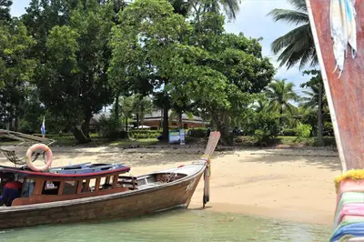 a boat is docked on the shore of a beach at Laguna Villas Boutique Hotel in Ko Yao Noi