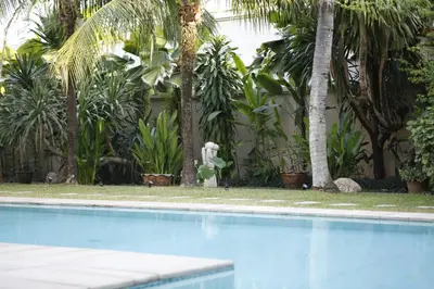 a swimming pool in front of a bunch of palm trees at The Residence Bantao Villa unit 121 in Bang Tao Beach