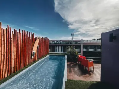 a swimming pool in front of a fence with a table and chairs at Must Sea Hotel - SHA Hotel in Kata Beach