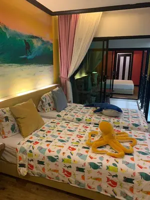 a bedroom with a bed with a yellow person on it at Must Sea Hotel - SHA Hotel in Kata Beach