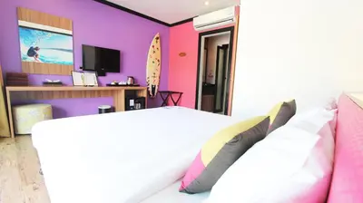 a bedroom with a white bed and a purple wall at Must Sea Hotel - SHA Hotel in Kata Beach
