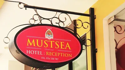 a red sign for a hotel reception at Must Sea Hotel - SHA Hotel in Kata Beach