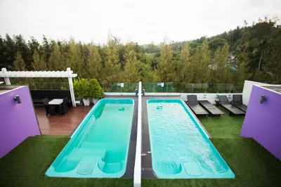 two swimming pools on the roof of a house at Must Sea Hotel - SHA Hotel in Kata Beach