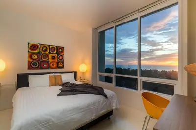 a bedroom with a bed and a large window at The Palm at Veloche Group by Lofty in Karon Beach