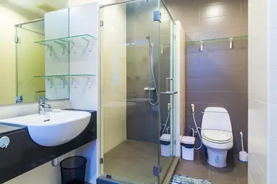a bathroom with a shower and a sink and a toilet at The Palm at Veloche Group by Lofty in Karon Beach