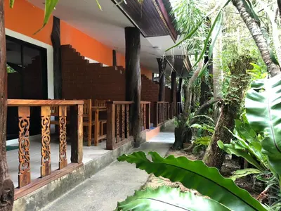 a porch of a house with wooden railing at Ruan Mai San Ngam Resort - SHA Plus in Nai Yang Beach