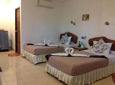 a bedroom with two beds with towels on them at Ruan Mai San Ngam Resort - SHA Plus in Nai Yang Beach