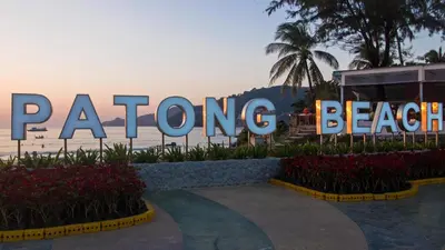 a sign for patong beach with the ocean in the background at PorterHouse Beach Hotel in Patong Beach