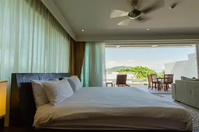 a bedroom with a bed and a large window at Dahlia 2 Bedroom Amazing Seaview in Rawai Beach