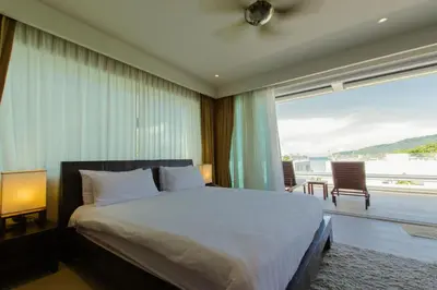 a bedroom with a large bed and a large window at Dahlia 2 Bedroom Amazing Seaview in Rawai Beach