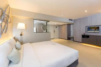 a bedroom with a large white bed in a room at Pearl Hotel Phuket in Phuket Town