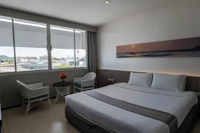 a hotel room with a bed and a large window at Pearl Hotel Phuket in Phuket Town