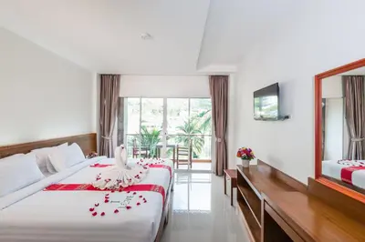 a hotel room with a bed and a mirror at Baan Vanida Garden Resort in Karon Beach