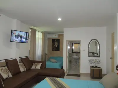 a living room with a couch and a mirror at Similan Hotel in Bang Tao Beach