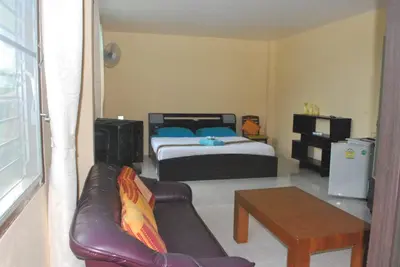 a living room with a bed and a couch and a table at Similan Hotel in Bang Tao Beach