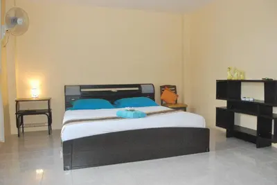 a bedroom with a large bed with blue pillows at Similan Hotel in Bang Tao Beach