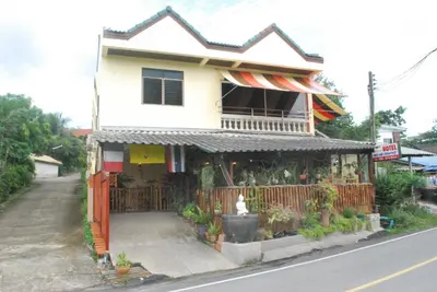 a house with a flower shop on the side of the street at Similan Hotel in Bang Tao Beach