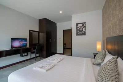 a bedroom with a white bed with two towels on it at Amarin Hotel Patong in Patong Beach